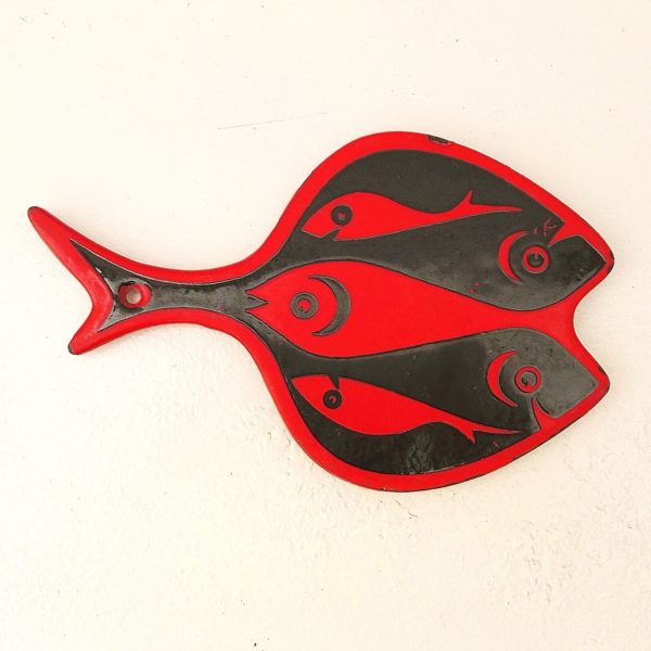 Ancien dessous de plat en fonte émaillée rouge et noir datant des années 70, à la forme de poisson, fabriqué au Danemark. Signé Voss Trace de rayures d'usage, éclats d'émail sur le contour. Les patins sont usés. Dimensions : 24 x 15 cm