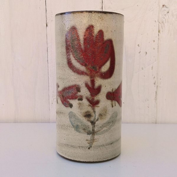 Vase rouleau en céramique par Gustave Reynaud pour le Mûrier à Vallauris. Décor à la fleur rouge. Un éclat et égrenure au col ainsi qu'un choc sous le vase. Bon état général. Hauteur : 17 cm Diamètre : 8 cm
