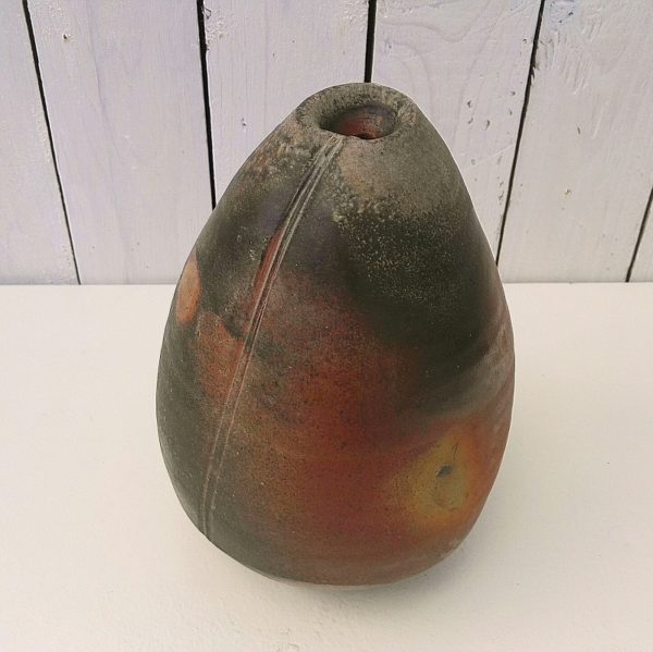 Grand vase soliflore en grès, de forme libre, crée par Eric Astoul à La Borne. Plusieurs cuisons au feu de bois lui donne cette couleur feu. Signé sur le dessous.  Un saut d'émail au col. Très bon état. Hauteur : 25 cm