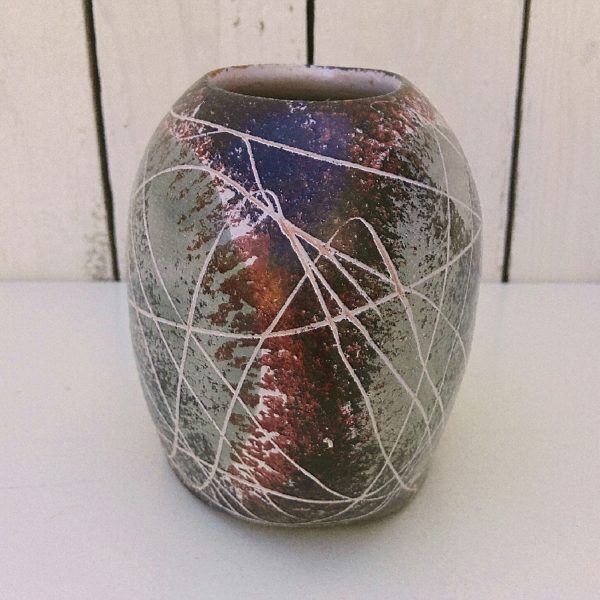Vase de forme organique en céramique, à décor de scarifications dans les tons prune, noir et vert céladon effet moucheté. Deux égrenures sur le col. Bon état général. Hauteur : 13,5 cm