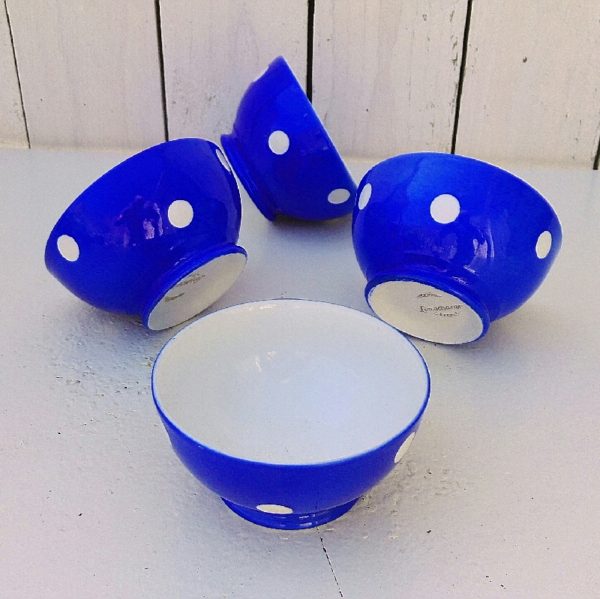 Lot de quatre bols bleus à pois blancs , en porcelaine de Longchamp, datant des années 50-60. Un éclat sur le rebord d'un bol. Bon état général. Hauteur : 5,5 cm Diamètre : 9,5 cm