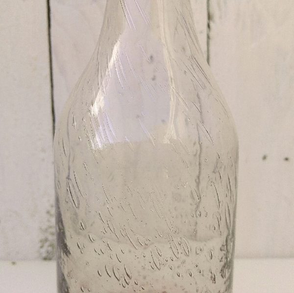  Bouteille en verre soufflé de la verrerie de Biot. Les bulles dans le verre sont typiques de cette manufacture. De couleur rose pale. Petites traces de calcaire à l'intérieur. Très bon état. Hauteur : 23 cm