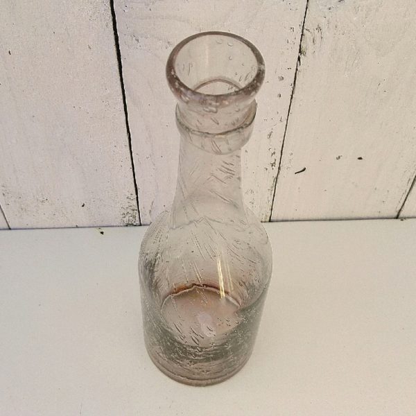  Bouteille en verre soufflé de la verrerie de Biot. Les bulles dans le verre sont typiques de cette manufacture. De couleur rose pale. Petites traces de calcaire à l'intérieur. Très bon état. Hauteur : 23 cm
