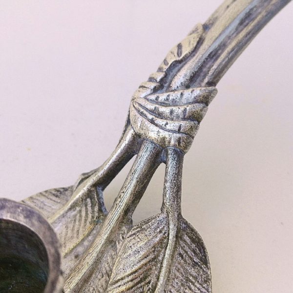 Bougeoir à main en bronze argenté datant du XIXème siècle. Coupe ciselée reposant sur trois feuilles pourvues de leur tige, maintenues grâce à un ruban. Trace d'oxydation. Très bon état. Longueur : 22 cm