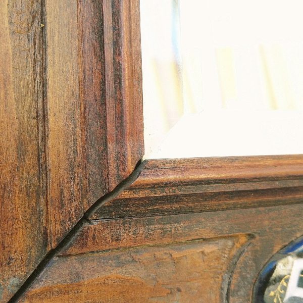 Ancien miroir en bois serti de cabochons émaillés en relief, datant de 1880. Les cabochons de droite et gauche sont monogrammés.  Miroir intérieur épais et biseauté. Des sauts d'émail sur les cabochons haut, bas et de droite. Un point d'accroche sur l'arrière. Bon état général. Dimensions totales : 35 x 39,5 cm Dimensions miroir : 17 x 21 cm