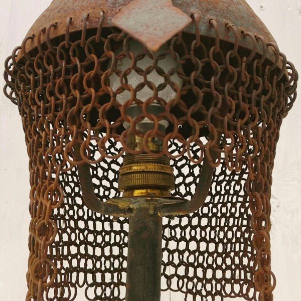 Lampe tripode casque Indo-persan dit Kulah Khud. En fer forgé avec une pointe sur le haut du casque qui est entouré de son camail. Electrification d'origine. Corrosion sur l'ensemble de la lampe lui donnant un aspect moyenâgeux . Bon état général Hauteur avec pointe : ~32 cm