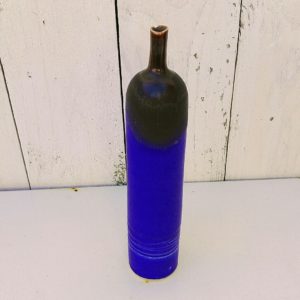 Vase soliflore à col étroit en céramique émaillée dans des nuances de bleues nuit et noires. De fabrication scandinave. Un petit éclat au col. Bon état général. Hauteur : 19,5 cm