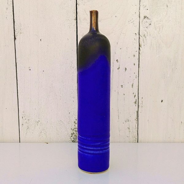 Vase soliflore à col étroit en céramique émaillée dans des nuances de bleues nuit et noires. De fabrication scandinave. Un petit éclat au col. Bon état général. Hauteur : 19,5 cm