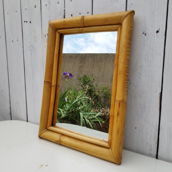 Miroir rectangulaire en bambou et rotin, datant des années 60. Petites rayures sur le miroir sans gravité, traces d'usage. Très bon état. Dimensions : 36,5 x 26 cm