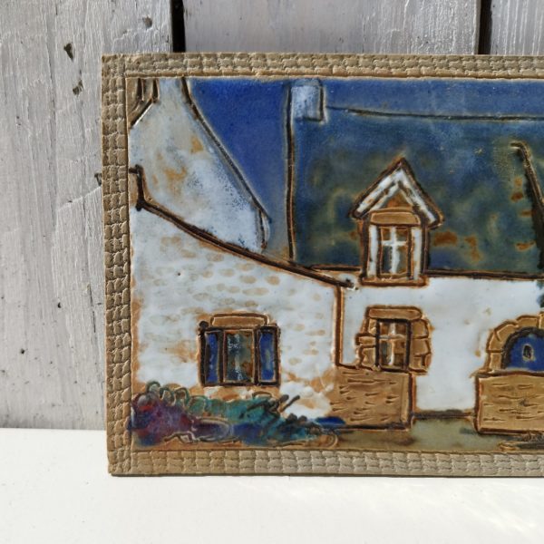 Carreau de céramique représentant une maison typiquement bretonne. Une signature en creux à l'arrière. excellent état. dimensions : 20,5 x 13 cm