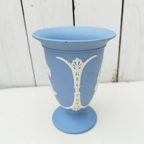 Vase en biscuit bleu et blanc signé Wedgwood, manufacture anglaise. Avec un décor de personnages à l'antique donnant l'impression d'un camée. Excellent état. Hauteur : 14 cm