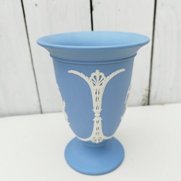 Vase en biscuit bleu et blanc signé Wedgwood, manufacture anglaise. Avec un décor de personnages à l'antique donnant l'impression d'un camée. Excellent état. Hauteur : 14 cm