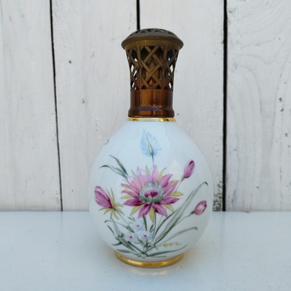 Lampe berger à décor floral en porcelaine de Limoges, signée Camille Tharaud. Modèle complet avec une boite de mèche. Très bon état. Hauteur : 18 cm