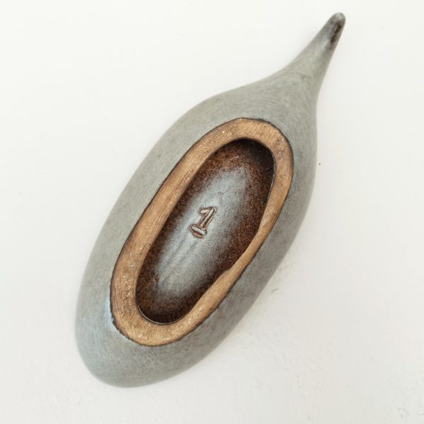 Vide poche en céramique de couleur gris par  Max Idlas datant des années 60. Une petite poignée recourbée sur le bout. Numéro 1 en creux sur le dessous. Je possède le numéro 1,2,et 3, et l'étiquette d'origine est sur le N°2. Excellent état Longueur : 26,5 cm Largeur : 10 cm