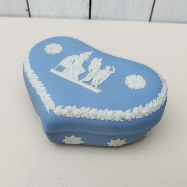 Boite en forme de coeur en biscuit bleu et blanc signé Wedgwood, manufacture anglaise. Avec un décor de personnages à l'antique donnant l'impression d'un camée. Excellent état. Hauteur fermée : 4,5 cm Dimensions boite : 14 x 9 cm