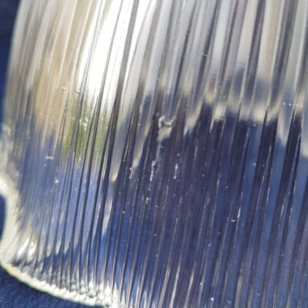 Suspension en verre strié datant des années 50 de la marque holophane. La particularité des ces verres est la très bonne diffusion de la lumière. Possède sa griffe d’origine. Des petits éclats sur les arêtes des striures à peine visible. Très bon état. Hauteur avec griffe: ~32 cm. Diamètre: 24 cm.