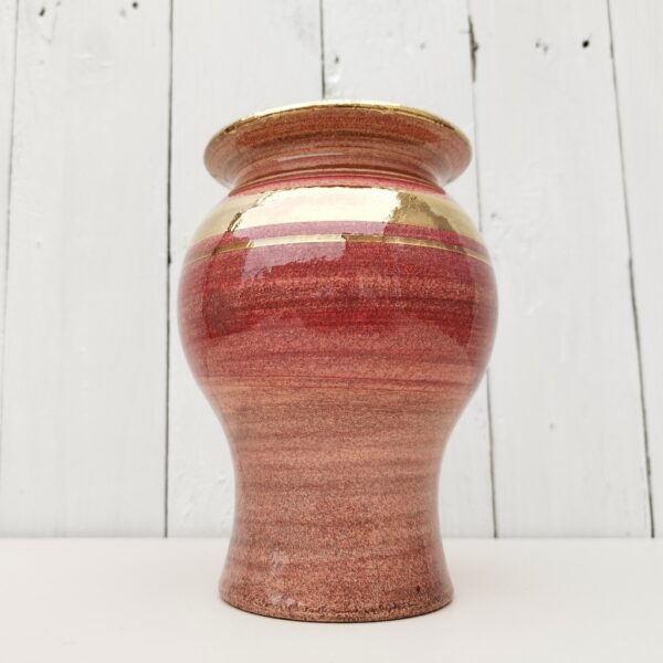 Vase en céramique crée par Georges Pelletier. Dans les tons rose, lie de vin, et dorure craquelée.. Micros égrenures sur le contour du col. Signé sur le pied du vase. Très bon état. Hauteur : 17,5 cm Diamètre : 11 cm