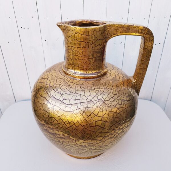 Très important et très lourd vase ( 12kg) en céramique de la fabrique artisanale Ernenwein à Marmoutiers en Alsace. Signé en dessous à la cigogne. Vase doré à la feuille d'or et aspect craquelé, de style art déco. Des éclats et égrenures sur le pourtour du talon. Bon état général. Hauteur : 45 cm Diamètre : 39 cm Circonférence : 118 cm
