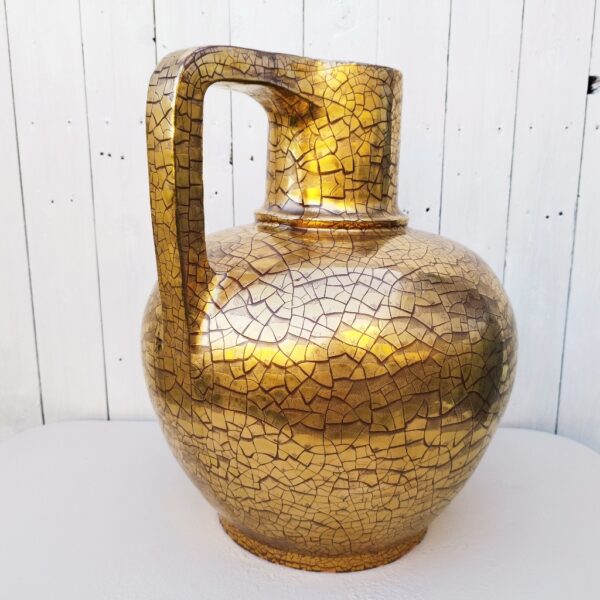Très important et très lourd vase ( 12kg) en céramique de la fabrique artisanale Ernenwein à Marmoutiers en Alsace. Signé en dessous à la cigogne. Vase doré à la feuille d'or et aspect craquelé, de style art déco. Des éclats et égrenures sur le pourtour du talon. Bon état général. Hauteur : 45 cm Diamètre : 39 cm Circonférence : 118 cm