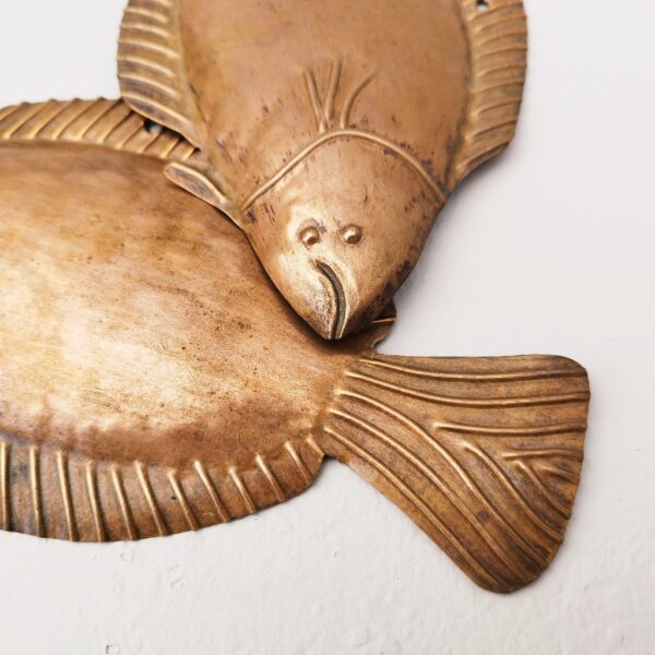 Deux poissons vénitiens en cuivre représentant une sole, décoration murale vintage. Un trou sur le haut pour les accrocher au mur. Petites rayures et traces d'usage. Dimensions : 22,5 x 13 cm