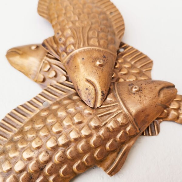 Trois poissons vénitiens en cuivre représentant une truite, décoration murale vintage. Un trou sur le haut pour les accrocher au mur. Petites rayures et traces d'usage. Dimensions : 22 x 8 cm