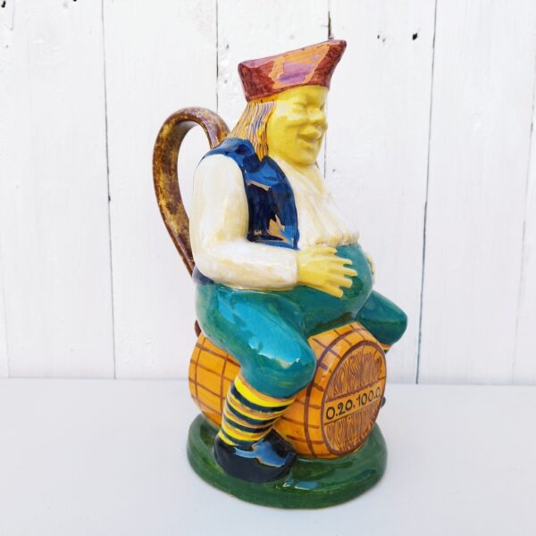 Pichet jacquot en céramique par Emile Tessier, représentant un tavernier bedonnant assis sur un tonneau. Signé sur le dessous. Excellent état. Hauteur : 27 cm