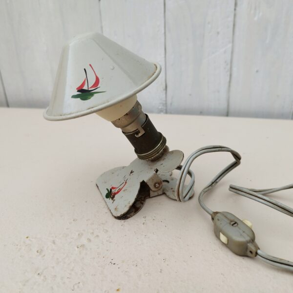 Petite lampe veilleuse, pince à la forme de champignon en tôle peinte. Datant des années 50. Traces de corrosion sur la pince, rayures d'usage. Ampoule baïonnette. Bon état général.