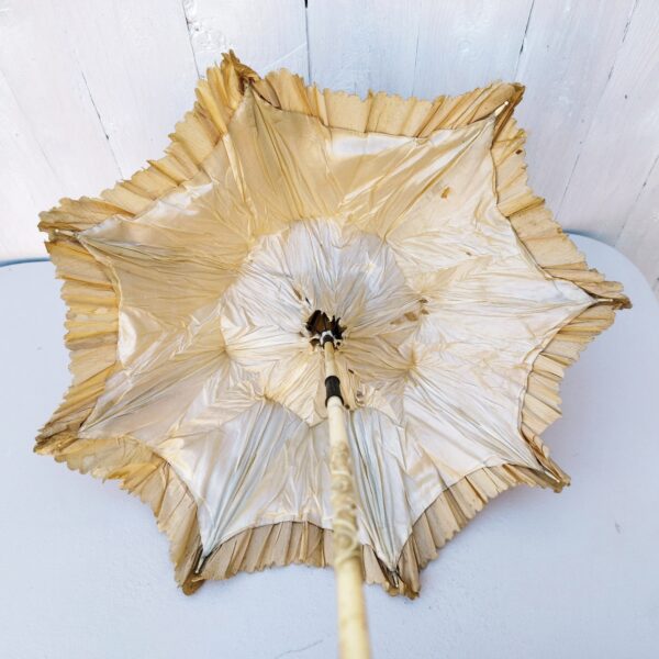 Ancienne ombrelle datant des années 1900-1920, manche en ivoire sculpté à décor de rose, orné d'une bague en argent ou métal argenté à décor floral, se terminant par une boule en ivoire sculpté représentant une rose. Pointe et bouts des baleines de l'ombrelle en ivoire. Un pompon rattaché à la pointe de l'ombrelle. Toile de l'ombrelle en soie. Déchirures de la soie sur l'intérieur et l'extérieur, manque une pointe de baleine, ivoire patiné à nettoyer.Coulant fonctionne bien. Dans son jus Longueur : 62,5 cm