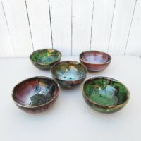 Lot de 5 bols en grès émaillé, par Matthieu Liévois. Trois dans les tons de vert et deux dans les tons de rose Un éclat sur le rebord  de deux bols.  signé à l'arrière. Bon état général. hauteur : 6,5 cm Diamètre : 13,5 cm