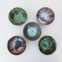 Lot de 5 bols en grès émaillé, par Matthieu Liévois. Trois dans les tons de vert et deux dans les tons de rose Un éclat sur le rebord  de deux bols.  signé à l'arrière. Bon état général. hauteur : 6,5 cm Diamètre : 13,5 cm