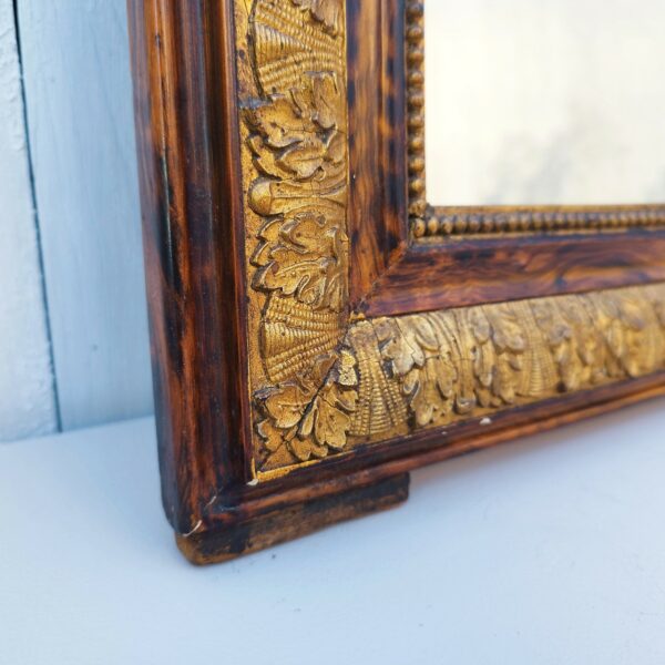 Ancien miroir style Louis Philippe en bois et dorure. Orné d'une frise florale. Une ficelle d'accroche à l'arrière. Miroir en très bon état.  Très bon état général. Dimensions : 61 x 48 cm