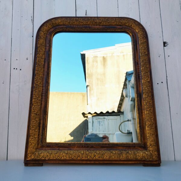 Ancien miroir style Louis Philippe en bois et dorure. Orné d'une frise florale. Une ficelle d'accroche à l'arrière. Miroir en très bon état.  Très bon état général. Dimensions : 61 x 48 cm