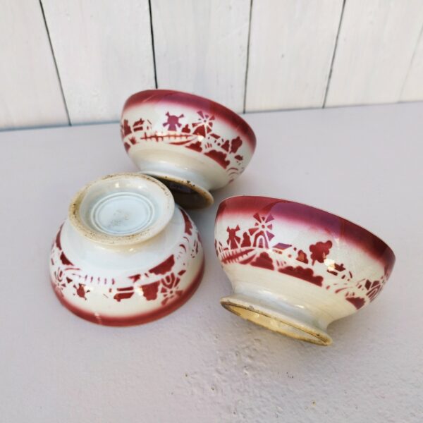 Série de 3 bols anciens datant des années 50, en faïence  à décor ode moulins. Traces d'usage à l'intérieur. Des fèles et quelques égrenures sur les rebords Dans leur jus Diamètre : 11,5 cm Hauteur : 6 cm
