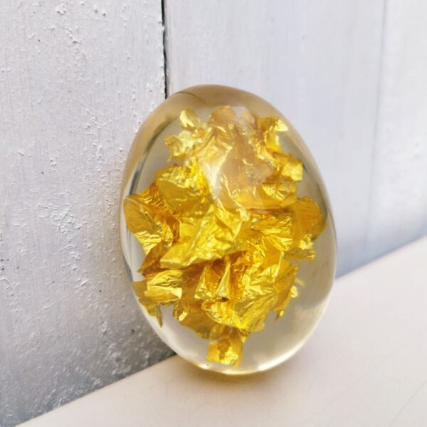  Inclusion d'une feuille d'or dans du plexiglas à la forme d'un oeuf, idéal comme décoration pour un cabinet de curiosité. Rayures d'usage sur le plexiglas Longueur : ~6,5 cm