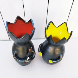 Paire de vases anthropomorphe faisant penser à des chats, en céramique noire avec intérieur jaune et l'autre rouge . Rappel de la couleur intérieur sur leurs mains. Le rouge tient une baguette. Manque un bout de la main du rouge. Très bon état. Hauteur jaune : 17,5 cm Hauteur Rouge : 19,5 cm