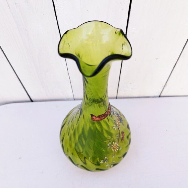 Vase soliflore en verre, décor d'un brin fleuri émaillé, collerette en vaguelette. Verre tourné de couleur vert  olive. Traces de calcaire à l'intérieur. Bon état général. Hauteur : 25,5 cm