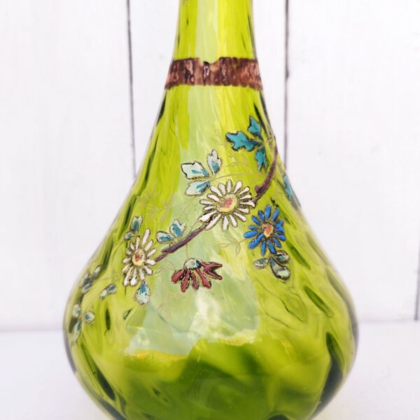 Vase soliflore en verre, décor d'un brin fleuri émaillé, collerette en vaguelette. Verre tourné de couleur vert  olive. Traces de calcaire à l'intérieur. Bon état général. Hauteur : 25,5 cm