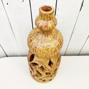 Lampe en céramique ajourée, datant des années 60. A décor de feuilles, signé sur le dessous. Faisant penser au travail d'Agnés Escala .Non électrifiée. Possibilité de mettre une double douille afin d'avoir un éclairage dans le pied et sur le haut. Sera certainement d'un plus bel effet. Très bon état général. Hauteur : 37 cm Diamètre : 15 cm