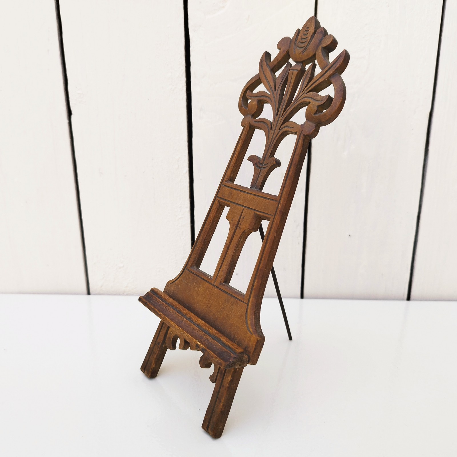 Ancien porte photo en bois sculpté à la forme de chevalet. Petites rayures et traces d'usage. Bon état général. Hauteur totale : 24 cm Largeur : 9 cm