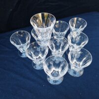Dix verres à vin blanc en verre à facettes , modèle style harcourt. De très belle facture. Une micro ébréchure sur le contour d'un verre  Bon état Hauteur  : 8,5 cm et diamètre : 7 cm
