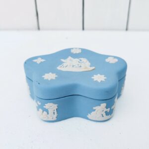 Boite en biscuit bleu et blanc signé Wedgwood, manufacture anglaise. Avec un décor de personnages à l'antique donnant l'impression d'un camée. Excellent état. Hauteur fermée : 3,5 cm Dimensions boite : 10 x 7 cm