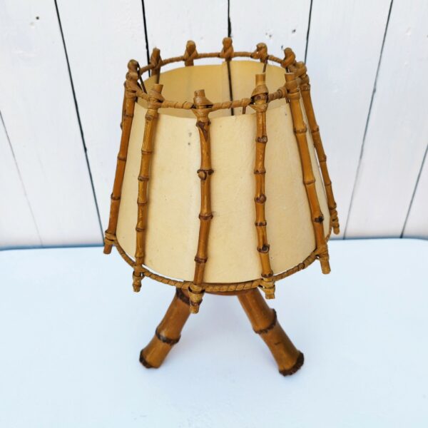 Lampe de chevet en bambou, abat jour de couleur blanc cassé, électrification d'origine. Petites taches sur l'abat-jour sans gravité. Très bon état Hauteur : 34,5 cm
