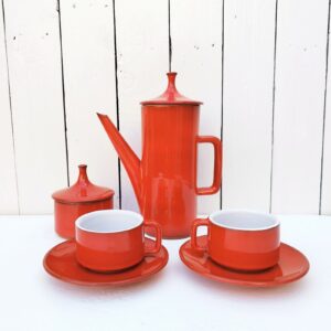 Tête-à-tête , petit déjeuner en céramique, comprenant une cafetière, un sucrier, et deux tasses. En céramique de la poterie de la Brague à Plascassier. Couleur rouge vif.  Signature en creux sur le dessous. Deux égrenures sur le couvercle du sucrier, une micro égrenure sur le contour d'une tasse. Très bon état général. Hauteur cafetière avec couvercle : 25 cm Hauteur sucrier avec couvercle : 11,5 cm Hauteur tasses : 5,5 cm et diamètre : 8 cm