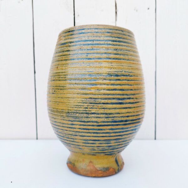 Vase ovoïde sur piédouche en grès vernissé strié. Des teintes de bleues dans les striures. Signé Pierre Pigaglio. Excellent état. Hauteur : 22 cm Diamètre : 11,5 cm