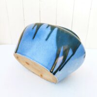 Jardinière ou cache pot en grès de Puisaye, par Léon Pointu. Décor flammé dans les tons bleus avec coulures noires irisées . Signée sur le dessous. Très bon état. Hauteur : 16 cm Longueurs max : 27 cm largeur max : 17 cm