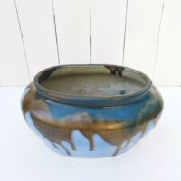 Jardinière ou cache pot en grès de Puisaye, par Léon Pointu. Décor flammé dans les tons bleus avec coulures noires irisées . Signée sur le dessous. Très bon état. Hauteur : 16 cm Longueurs max : 27 cm largeur max : 17 cm