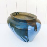 Jardinière ou cache pot en grès de Puisaye, par Léon Pointu. Décor flammé dans les tons bleus avec coulures noires irisées . Signée sur le dessous. Très bon état. Hauteur : 16 cm Longueurs max : 27 cm largeur max : 17 cm