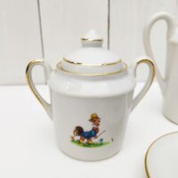  Service à café en porcelaine, dînette pour enfant. Composé d'une cafetière; d'un sucrier, d'un pot à lait et de quatre tasses + soucoupes. Décor d' animaux. Liseré doré. Une micro égrenure sur le rebord de deux tasses et sur l'intérieur d'un couvercle Bon état général Hauteur cafetière avec couvercle : 12,5 cm
