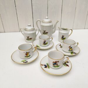  Service à café en porcelaine, dînette pour enfant. Composé d'une cafetière; d'un sucrier, d'un pot à lait et de quatre tasses + soucoupes. Décor d' animaux. Liseré doré. Une micro égrenure sur le rebord de deux tasses et sur l'intérieur d'un couvercle Bon état général Hauteur cafetière avec couvercle : 12,5 cm