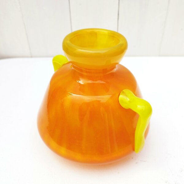 Vase à anse en verre soufflé, dans des tons très acidulés orange et jaune. Décor marmoréen. Signé à la pointe sur le bas, datant des années 20. Excellent état. Hauteur : 14 cm Diamètre  : 12,8 cm